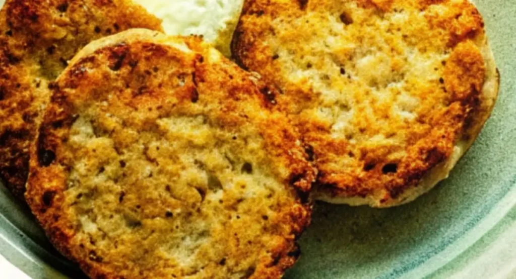 Close-up of golden-brown chicken apple sausage patties on a green plate.