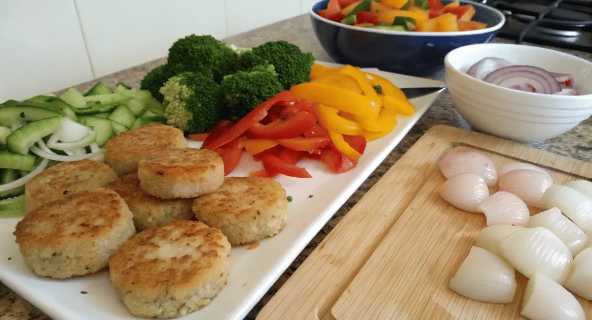 A vibrant fishcakes and scallops stir fry recipe in a wok, garnished with green onions, and sesame seeds.