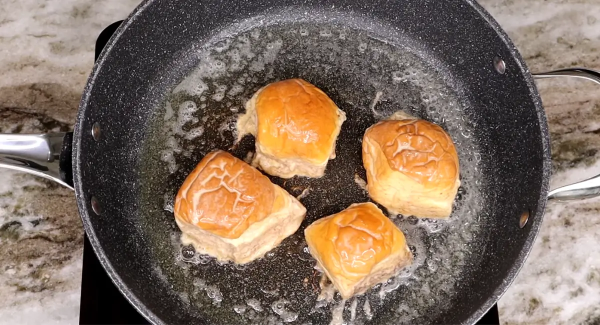 Hawaiian Roll French Toast being pan-fried in melted butter.