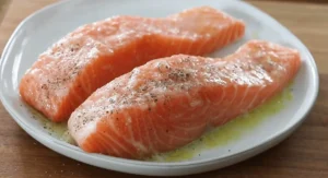 Fresh salmon fillets seasoned with salt and pepper, ready for cooking.