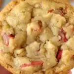 A single rhubarb cookies recipe being held in a hand against a blurred background.