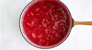 Simmering rhubarb sauce in a pot, a step in the rhubarb sauce recipe.