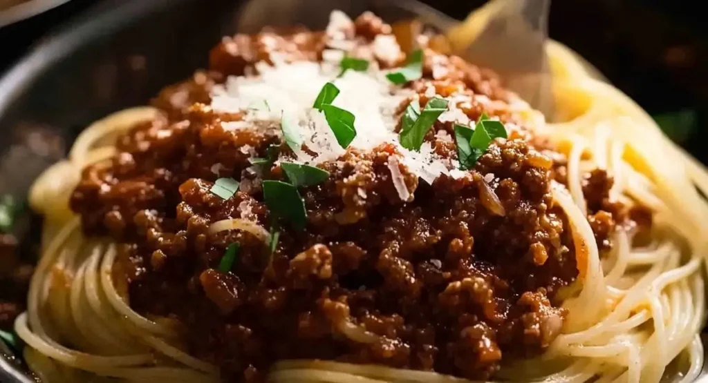 Close-up of spaghetti bolognese being served with cheese and parsley.