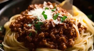 Close-up of spaghetti bolognese being served with cheese and parsley.