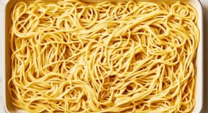 A rectangular baking dish filled with cooked spaghetti carbonara.