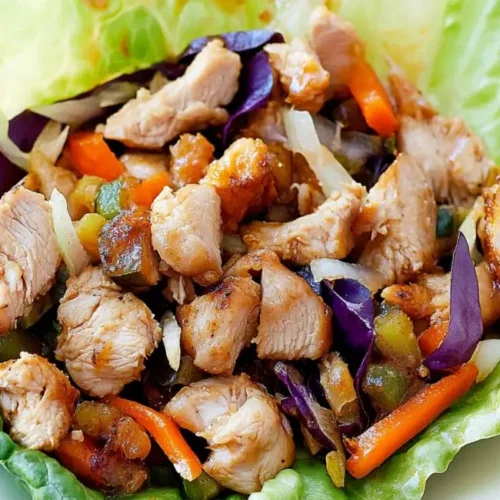Two servings of Healthy Honey Chicken Lettuce Wraps on a white plate.