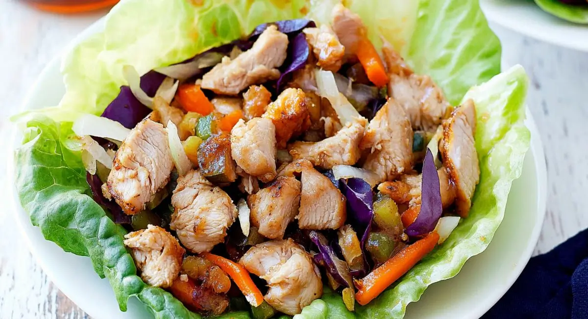 Two servings of Healthy Honey Chicken Lettuce Wraps on a white plate.