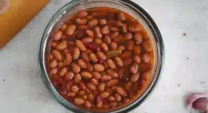 Kidney beans soaking in liquid, part of the Kashmiri Rajma Curry Recipe preparation.